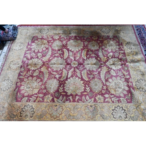 1053 - A contemporary Indo-Persian carpet, the wine-red ground with yellow-gold floral and leaf design, 304... 