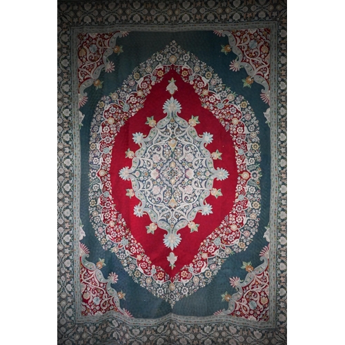 1054 - A good and large antique Kashmir crewel work carpet, first quarter 20th century, the soft red ground... 