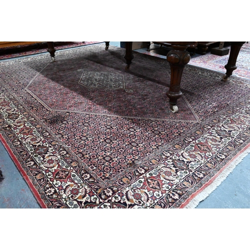1056 - A Persian Bidjar red ground carpet, centred by a diamond floral lozenge, 335 cm x 247 cm