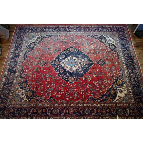 1070 - An Indo-Persian Kashan carpet, the red ground centred with a blue ground floral medallion