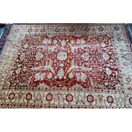 1075 - A contemporary Indian Agra carpet, the red-pink ground with stylised floral design, 323 cm x 242 cm