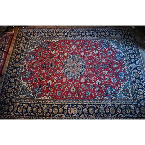 1079 - A central Persian Isfahan carpet, centred by a floral medallion on red ground, 380 cm x 285 cm