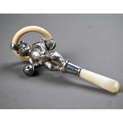 107 - Silver 'teddy bear' baby's rattle with composite teething ring, two bells and mother of pearl handle... 