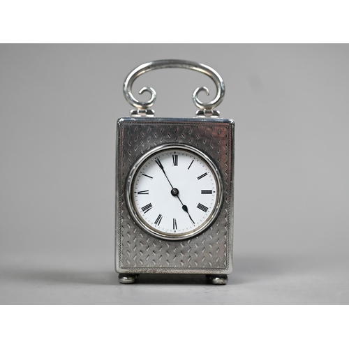 111 - A late Victorian silver boudoir clock with hinged top handle, engine-turned decoration and bun feet;... 