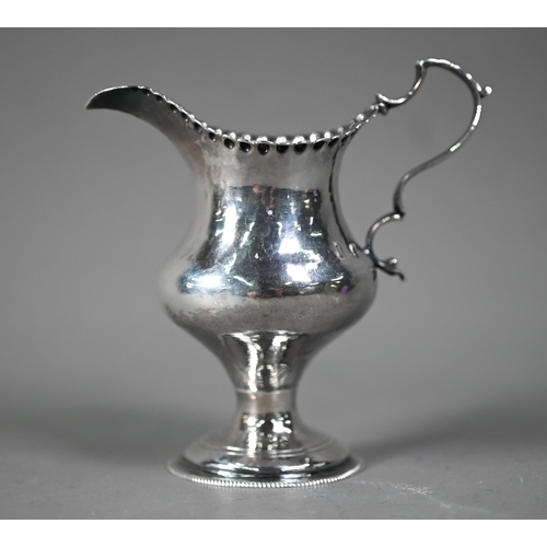 128 - Hester Bateman: a silver baluster cream jug with impressed beaded rim, scroll handle and stemmed cir... 