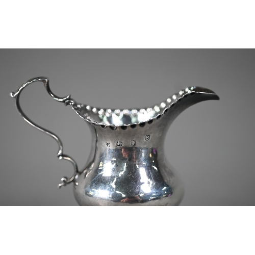 128 - Hester Bateman: a silver baluster cream jug with impressed beaded rim, scroll handle and stemmed cir... 