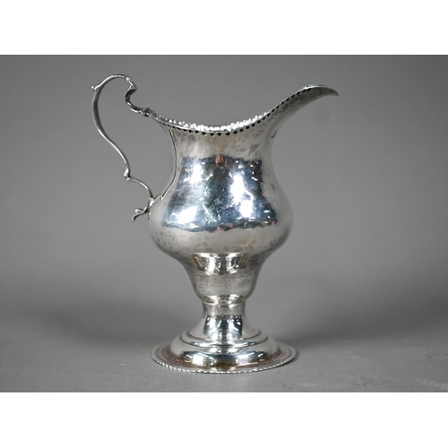 129 - Hester Bateman: a silver baluster cream jug with impressed beaded rim, scroll handle and stemmed cir... 