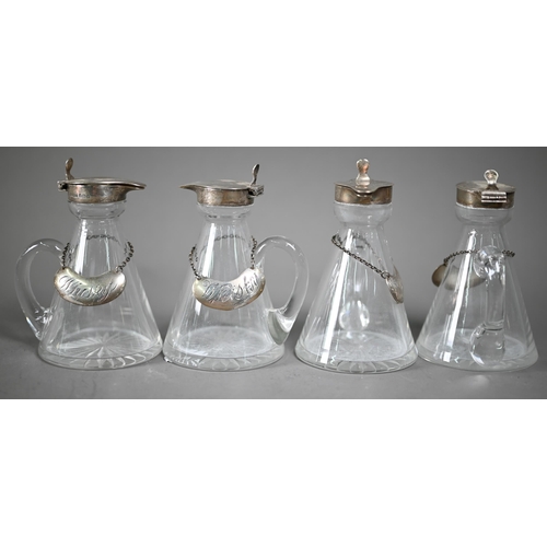 138 - A matched set of four conical glass whisky noggins with star-cut bases and silver collars and covers... 