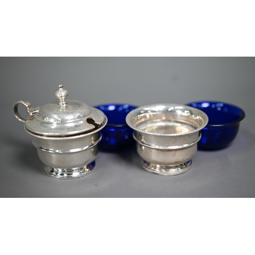 145 - A silver three-piece condiment set with blue glass liners, Birmingham 1932, to/w a pair of Dunstable... 