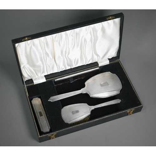 178 - An engine-turned silver four-piece brush set, Birmingham 1961/62, in presentation case