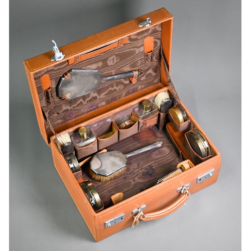 180 - A pigskin toilet case fitted with a silver brush set, glass jars with gilt metal covers and leather ... 