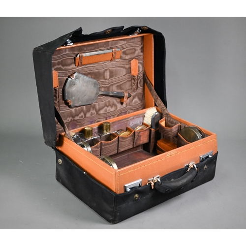 180 - A pigskin toilet case fitted with a silver brush set, glass jars with gilt metal covers and leather ... 