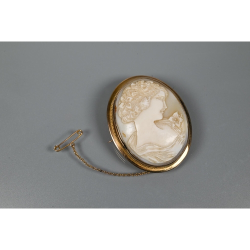 323 - An oval cameo brooch featuring bust of a young female, in yellow metal oval mount with rope twist de... 