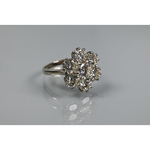 329 - A diamond cluster ring with six round brilliant cut diamonds surrounding a central round brilliant c... 
