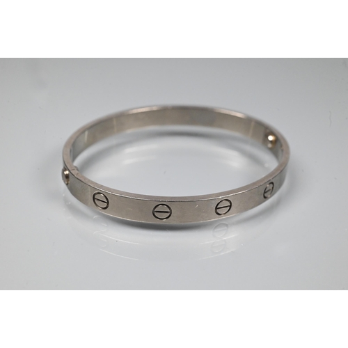 335 - Cartier - an oval 'love' bangle, white metal stamped 750, etched Cartier inscription numbered M.1653... 