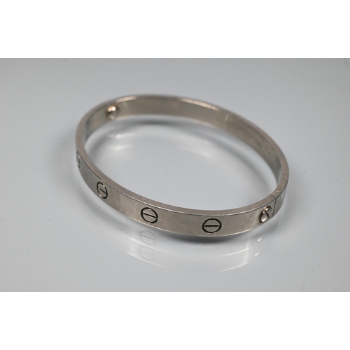 335 - Cartier - an oval 'love' bangle, white metal stamped 750, etched Cartier inscription numbered M.1653... 