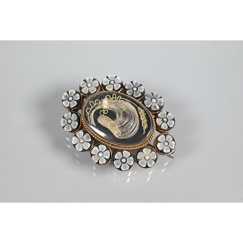 347 - A Victorian oval mourning brooch with plume of hairwork surrounded by carved flowers, closed back se... 