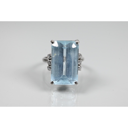 A rectangular aquamarine and diamond ring, the baguette cut aquamarine with three claw set diamonds to each side, 18ct white gold ring stamped 750, size P, the aquamarine approx 1.8 x 1 cm, approx 14 ct, 7.8 g all in