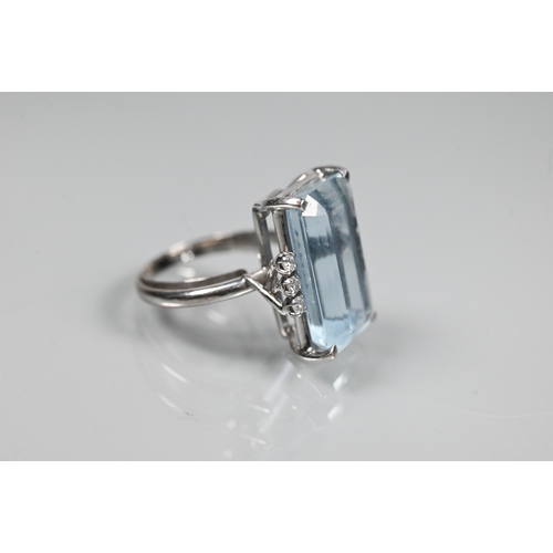 351 - A rectangular aquamarine and diamond ring, the baguette cut aquamarine with three claw set diamonds ... 