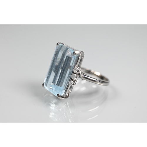 351 - A rectangular aquamarine and diamond ring, the baguette cut aquamarine with three claw set diamonds ... 