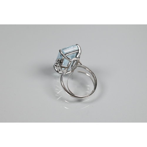 351 - A rectangular aquamarine and diamond ring, the baguette cut aquamarine with three claw set diamonds ... 