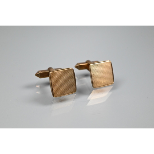 353 - A pair of 9ct yellow gold cufflinks of square design with engine-turned decoration, with swivel back... 