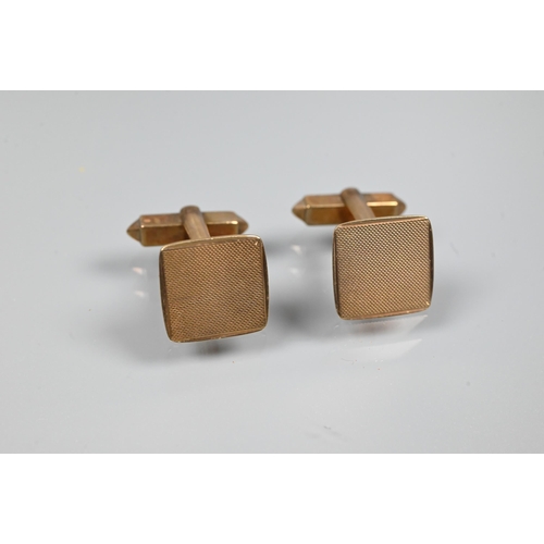 353 - A pair of 9ct yellow gold cufflinks of square design with engine-turned decoration, with swivel back... 