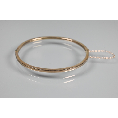 362 - A narrow oval half hinged bangle fitted with safety chain, unmarked and untested, approx 4.9g