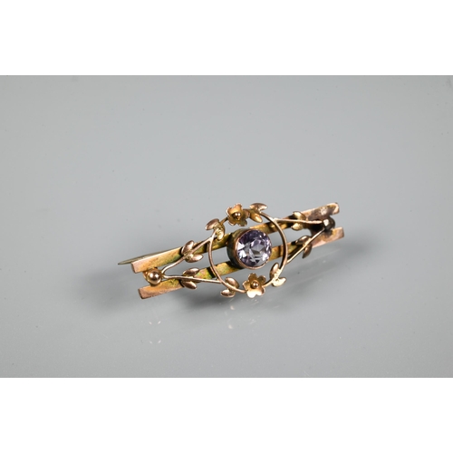 371 - A Victorian yellow metal bar brooch featuring flower and leaf motifs around a central pale semi-prec... 