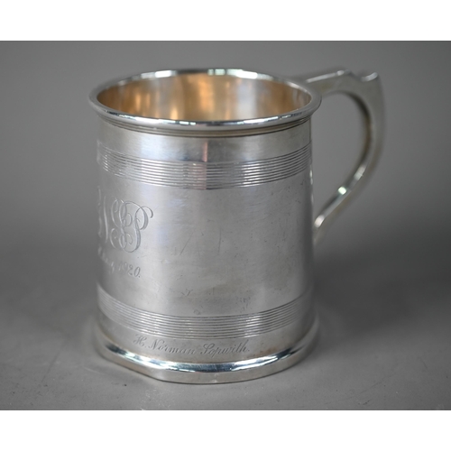 56 - Silver Christening mug in the Georgian manner, of tapering form with reeded bands and scroll handle,... 