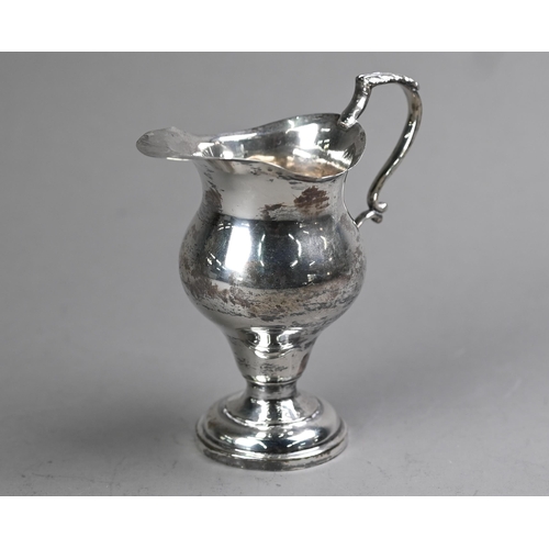 85 - An Edwardian silver baluster cream jug in the Georgian manner, with scroll handle and circular foot-... 