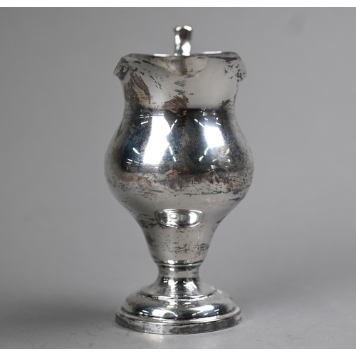 85 - An Edwardian silver baluster cream jug in the Georgian manner, with scroll handle and circular foot-... 