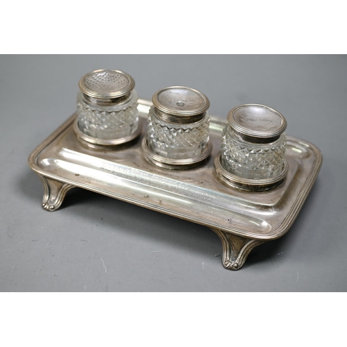 98 - A George IV silver inkstand with three silver-topped cut glass pots, with reeded rim and bracket fee... 