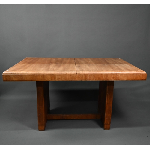 1021 - An Art Deco oak draw-leaf dining table, the top with integral folding central leaf, raised on slab e... 