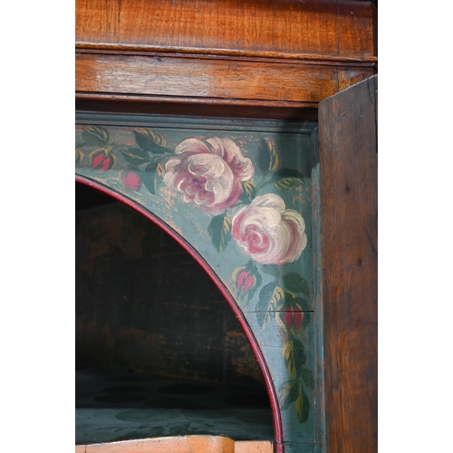 1028 - A Georgian oak corner cupboard, in two parts, the upper with broken swan-neck pediment over a pair o... 