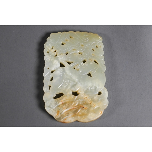 515 - A Chinese jade amulet or pendant, the pale celadon stone with white and russet inclusions intricatel... 
