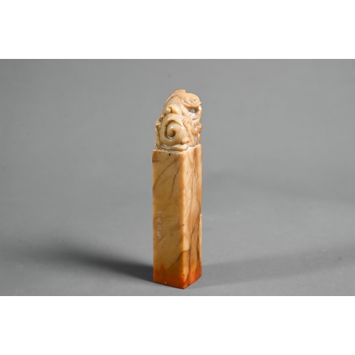 516 - A Chinese butterscotch coloured soapstone seal carved with a carp and wave finial, four character en... 