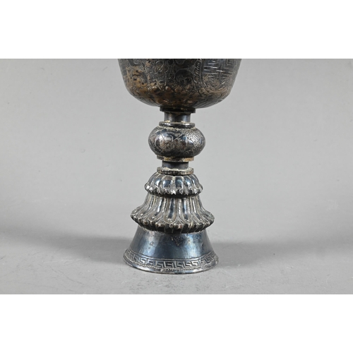 527 - A 19th century Tibetan silver yak butter lamp, the bowl with everted rim richly engraved with leiwen... 
