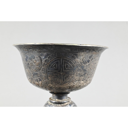 527 - A 19th century Tibetan silver yak butter lamp, the bowl with everted rim richly engraved with leiwen... 