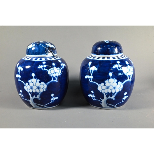 575 - A pair of 20th century Chinese blue and white prunus on cracked ice ginger jars and covers, 15 cm hi... 