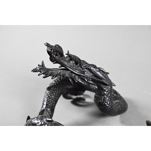 579 - A Chinese bronze three-clawed Mizuchi Dragon, modelled with long scaly, sinuous body and fierce expr... 