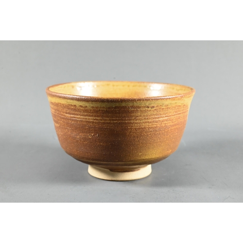 588 - A 20th century Japanese pottery Fujiwa-yaki honey glazed tea bowl (chawan) on triangular incised ung... 