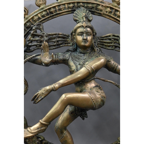 594 - A large Indian brass figure of Shiva Nataraja, the four-armed Hindu god holding a damuru drum and ag... 