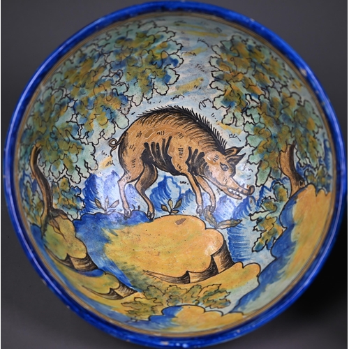 643 - A graduated pair of 19th century Italian majolica bowls, painted with a boar and a bull in woodland ... 