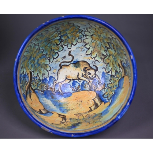 643 - A graduated pair of 19th century Italian majolica bowls, painted with a boar and a bull in woodland ... 