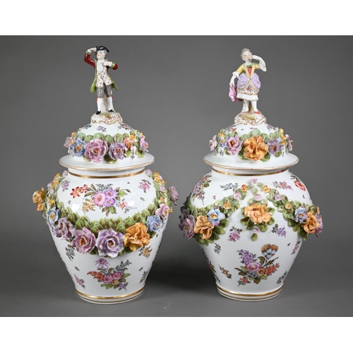 668 - A good pair of German porcelain vases, the domed covers surmounted by an 18th century lady and gentl... 