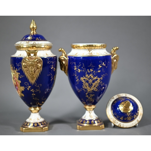 691 - A pair of boxed Coalport blue-ground urns and covers, the reserves painted with fruit still lifes ar... 