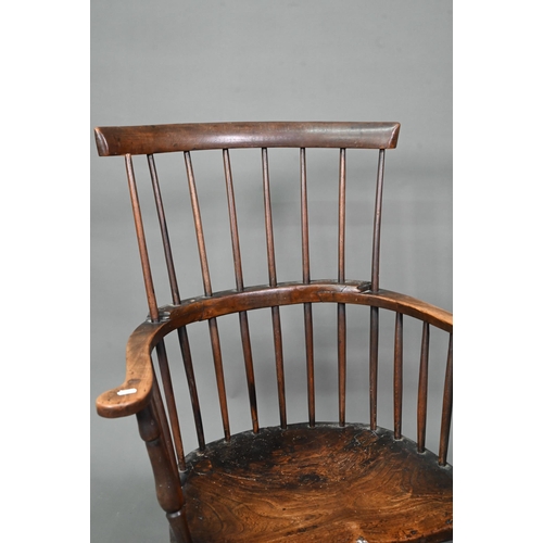 902 - An antique elm seat comb-back chair, raised on turned legs united by an H-stretcher