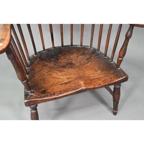 902 - An antique elm seat comb-back chair, raised on turned legs united by an H-stretcher