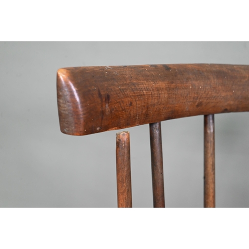 902 - An antique elm seat comb-back chair, raised on turned legs united by an H-stretcher